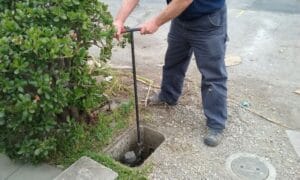 man turning off exposed primary water shutoff valve