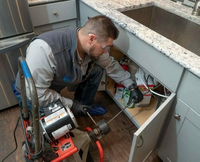 reliant plumbing plumber cleaning a sewer drain line