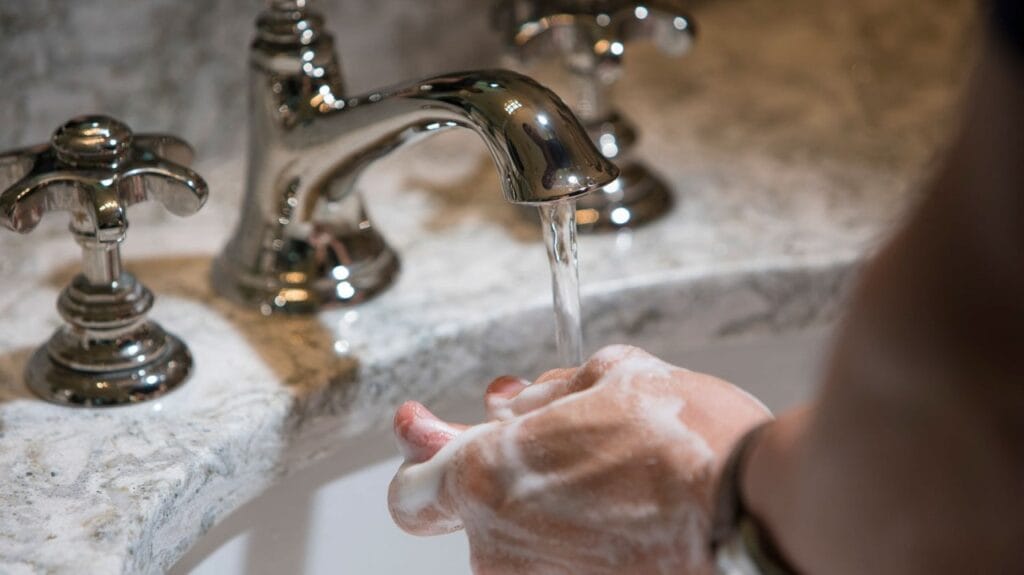 woman washing hands in sink
