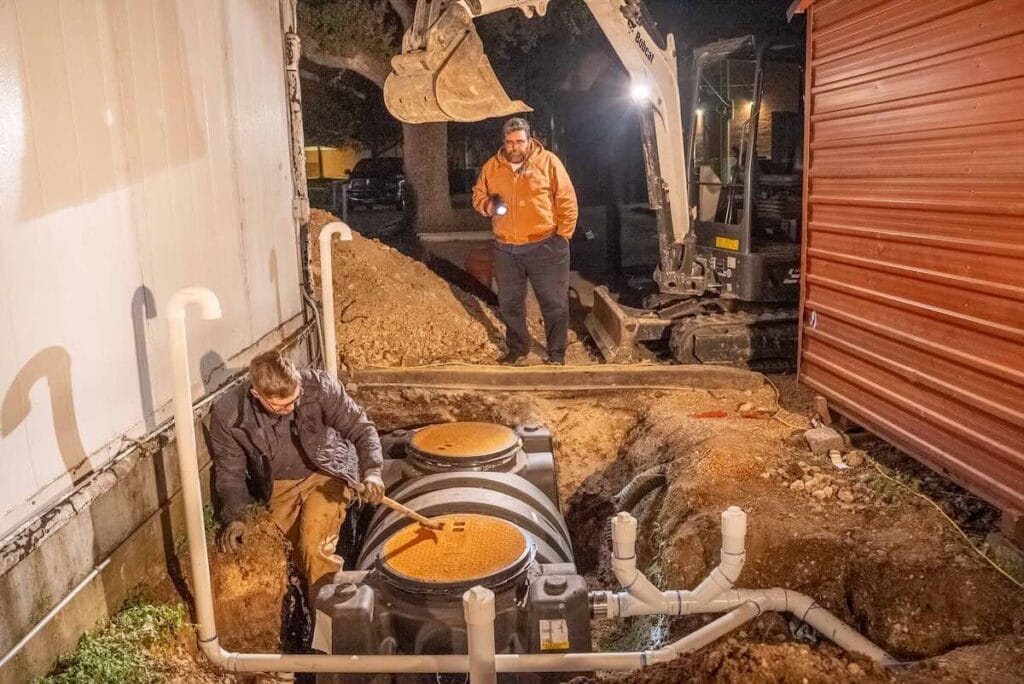 team of plumbers working on a grease trap
