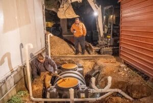 team of plumbers working on a grease trap