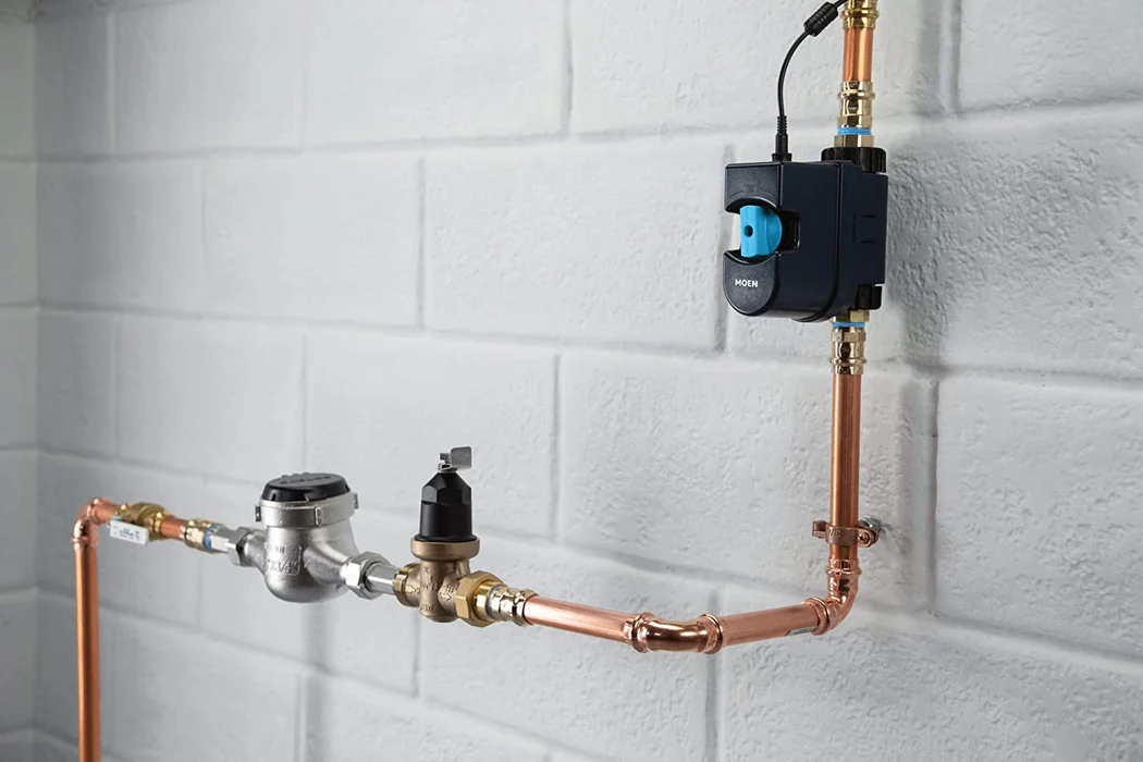 Moen Flo Smart Water Monitor & Shutoff Moen Flow Smart Water Monitor and Shutoff installed in copper piping against a wall