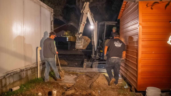 two reliant plumber standing with excavator while working on a commercial grease trap replacement
