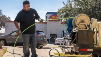 reliant plumbing technician running a jetter to clean out a commercial drain in front of a Taco Palenque