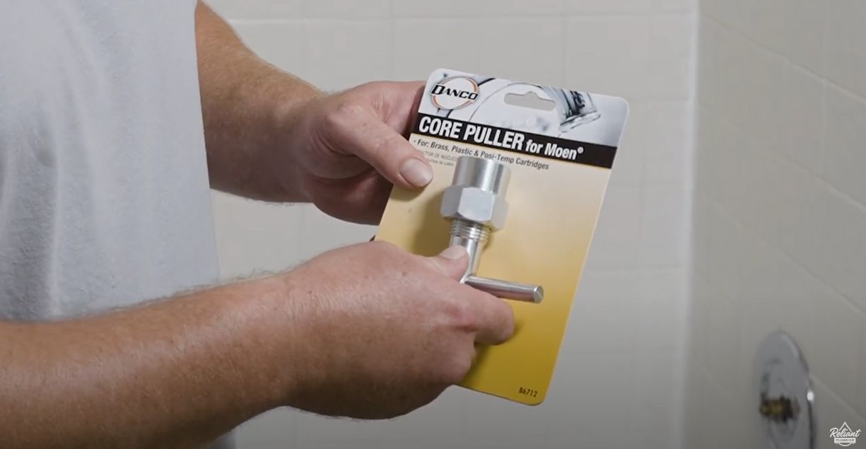 hands holding a core puller in it's packaging and the packaging says core puller for moen