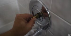 a hand pushes the shower cartridge back into the stem