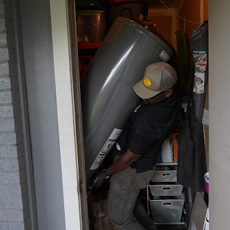 Reliant Plumbing technician installing a water heater in a home