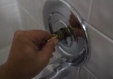 a hand pushes the shower cartridge back into the stem