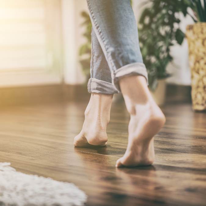 barefoot walking across floor to feel for warm spots indicating a slab leak